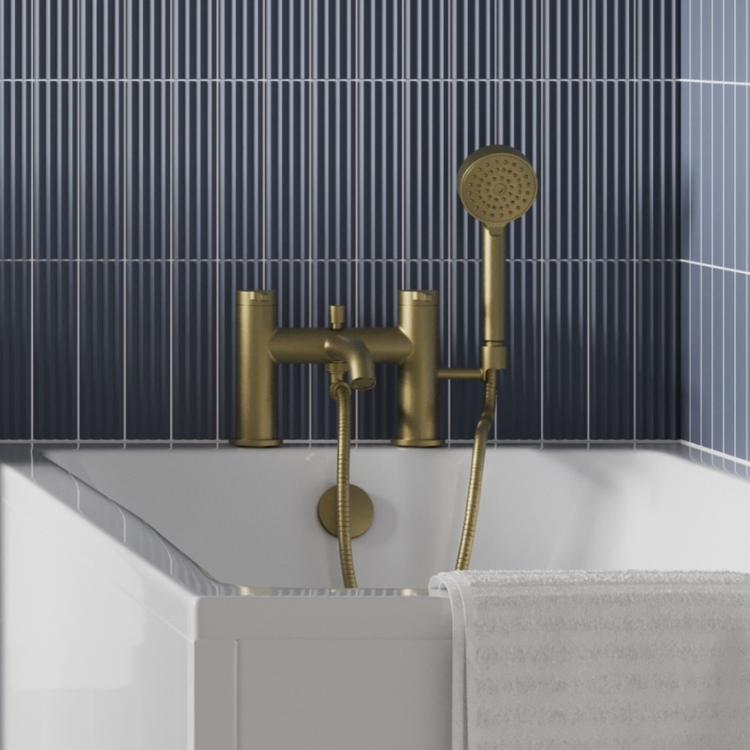 product lifestyle image of Britton Hoxton 2.0 Brushed Brass Bath Shower Mixer Tap fitted to bath next to blue vertical lined tiles HOX422DF